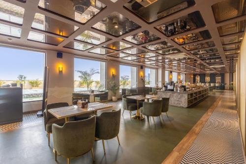 a restaurant with tables and chairs and large windows at Saltstayz Premier Suite Chandigarh Mohali in Sohāna