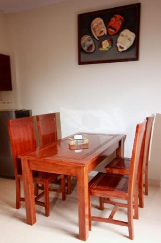 a wooden dining room table with chairs and a picture at Natha Ubud Villa in Ubud