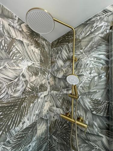 a bathroom with a wall with a palm leaf wallpaper at Studio apartmani villa Nicol in Pirovac