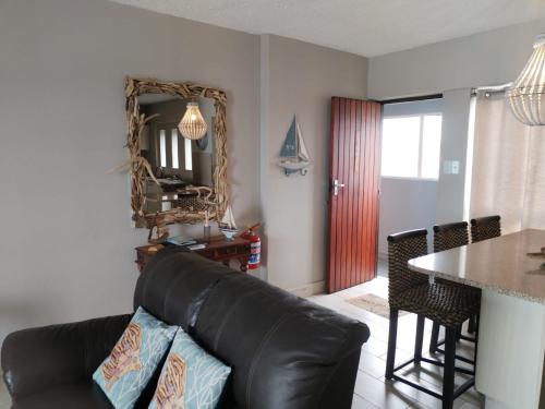 ダーバンにある138 Stella Maris, 73 Beach Road, Amanzimtoti Durban South Africaのリビングルーム(黒い革張りのソファ、テーブル付)