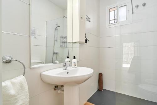 a white bathroom with a sink and a shower at Casa Rural El Granado in Nerja