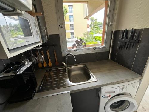 une petite cuisine avec un évier et une fenêtre dans l'établissement Condo in a private residence with pool, à Nice