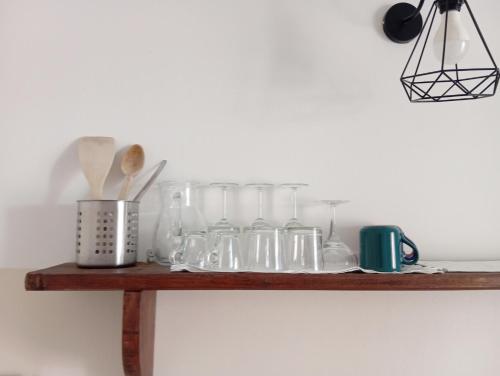 a wooden shelf with glass jars on it at Casa Viaemilia Alessandria in Alessandria