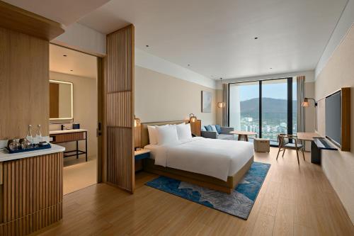 a hotel room with a bed and a desk at Hyatt Place Ha Long Bay, Bai Chay in Ha Long