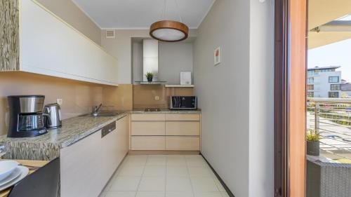 a kitchen with white cabinets and a large window at Foka, Sun & Snow in Hel