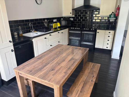 une cuisine avec une table en bois et des appareils noirs dans l'établissement Cosy village House Charroux, à Charroux