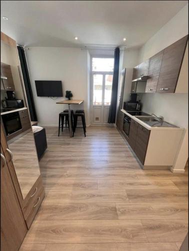 une grande cuisine avec une table et un comptoir dans l'établissement Studio Centre Cannes la bocca - 5 min des plages - WIFI Clim, à Cannes