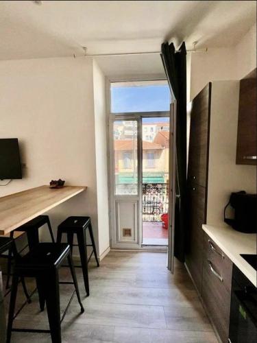 une cuisine avec une table et des chaises et une fenêtre dans l'établissement Studio Centre Cannes la bocca - 5 min des plages - WIFI Clim, à Cannes