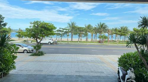 a street with cars parked next to the beach at Grand Gold Hotel in Danang