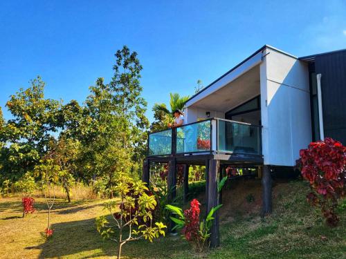 チェンライにあるHug Doi Homestay Chiang Raiの丘の上の家のバルコニーに人がいる
