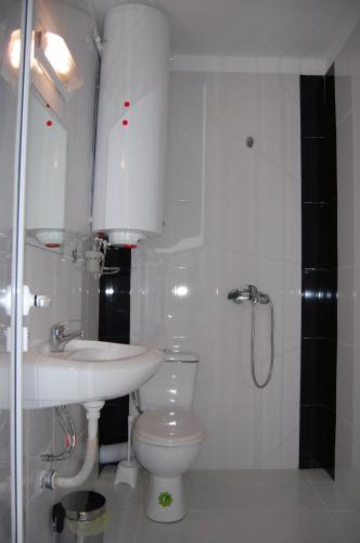a white bathroom with a sink and a toilet at Apartments Ivelin in Lozenets