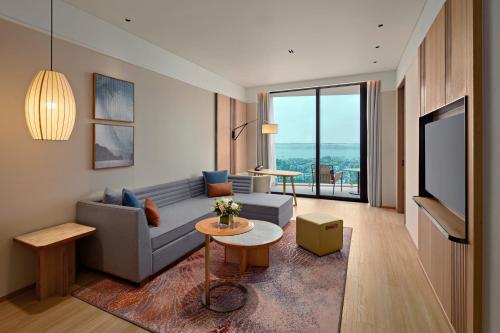 a living room with a couch and a tv at Hyatt Place Ha Long Bay, Bai Chay in Ha Long
