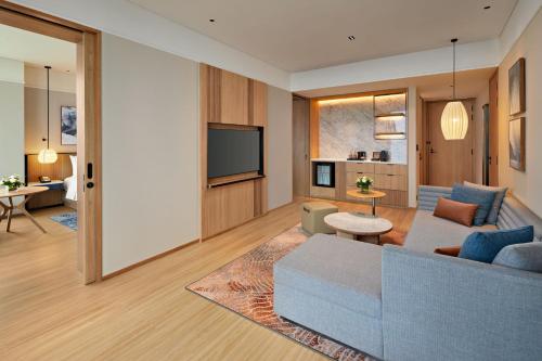 a living room with a couch and a tv at Hyatt Place Ha Long Bay, Bai Chay in Ha Long