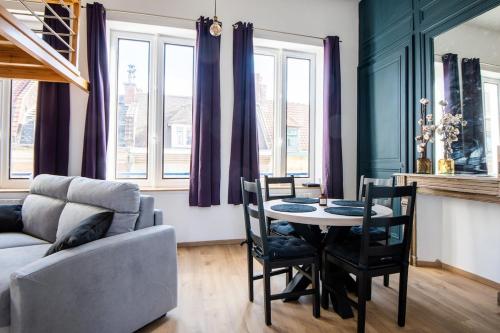 un salon avec une table, des chaises et un canapé dans l'établissement Elegant Studio with Mezzanine - amazing location, à Lille