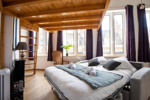 - une chambre avec un grand lit dans une pièce dotée de fenêtres dans l'établissement Elegant Studio with Mezzanine - amazing location, à Lille