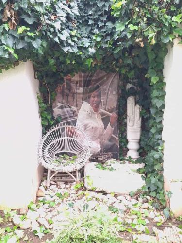 a man sitting in a chair in a garden at Vardos Lifestyle Guest House in Soweto
