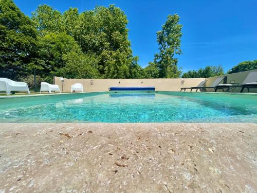a swimming pool with blue water and white chairs at " Ô Chai Nous " 14 pers - Billard, Babyfoot - Structure de Jeux in Poucharramet