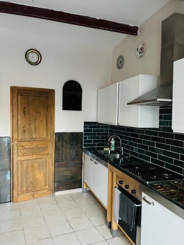 a kitchen with white cabinets and a stove top oven at Capescrown lodge in Capestang