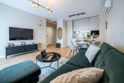 a living room with a green couch and a table at Oasis Apartment Strzelecka 57 in Bydgoszcz