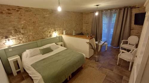 une chambre avec un lit, une table et des chaises dans l'établissement Domaine de la Tardoire, à Oradour-sur-Vayres