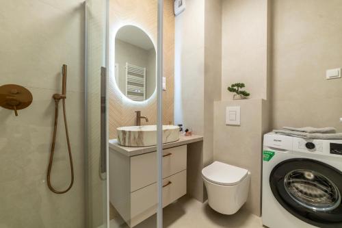 a bathroom with a sink and a washing machine at Oasis Apartment Strzelecka 57 in Bydgoszcz