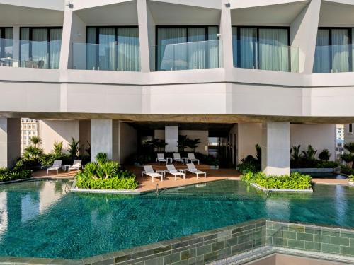 an external view of a building with a swimming pool at Hyatt Place Ha Long Bay, Bai Chay in Ha Long