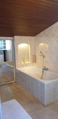 a bath tub with a faucet in a bathroom at Villa Solary in Le Pontet