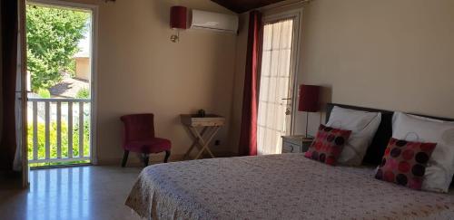 a bedroom with a bed and a chair and a window at Villa Solary in Le Pontet