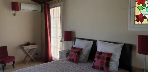 a bedroom with a bed with pillows and a window at Villa Solary in Le Pontet
