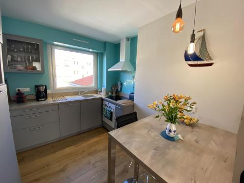 une cuisine avec une table avec un vase de fleurs dessus dans l'établissement Appartement Le Leon, à La Rudelière