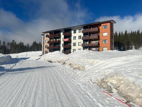 a snow covered road in front of a building at Ylläs Chalet 4 Ski-In, Incl 2 winter lift passes in Ylläsjärvi