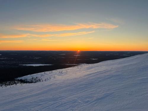 a sunset on top of a snow covered mountain at Ylläs Chalet 4 Ski-In, Incl 2 winter lift passes in Ylläsjärvi
