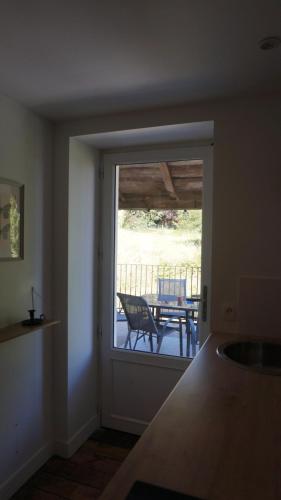 d'une cuisine avec une porte coulissante en verre s'ouvrant sur une terrasse. dans l'établissement Chez Audrey & Fabien - Appartement avec terrasse, à Saint-Pantaléon-de-Larche