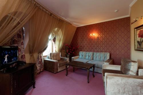 a living room with a couch and chairs and a tv at Kristel Hotel in St. St. Constantine and Helena