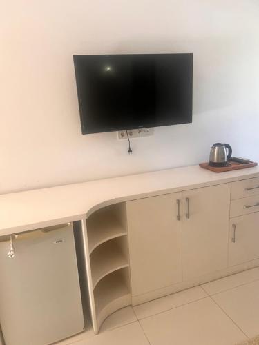 a desk with a flat screen tv on a wall at Umayra Boutique Hotel in Bodrum City