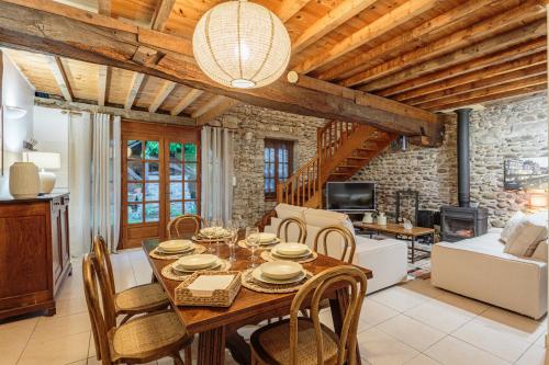 a dining room with a wooden table and chairs at Domaine Le Pehau 4 - Avec jardin et terrasse in Osserain-Rivareyte