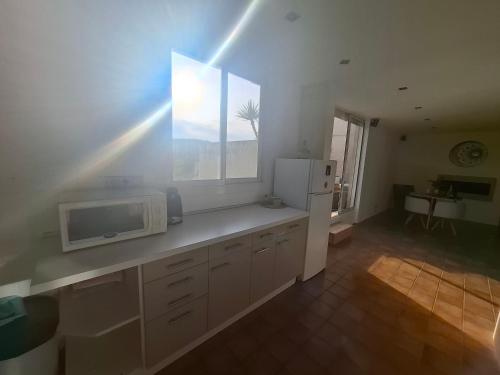 une cuisine avec un réfrigérateur blanc et une fenêtre dans l'établissement Le Cap Inné, à Draguignan