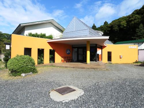 a yellow building with a pointed roof at Ryokan Kamomeso in Sado