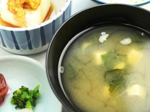 a bowl of soup next to a bowl of food at Ryokan Kamomeso in Sado