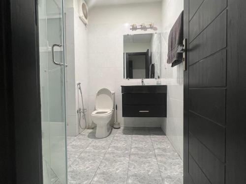 a bathroom with a toilet and a sink and a mirror at Luxor Apartments & Suites - Opal in Lahore