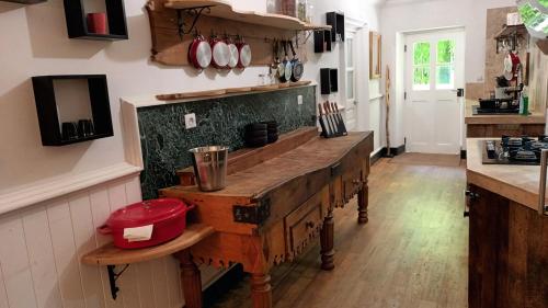 a kitchen with a wooden table in a room at Domaine Le Mayne in Chabrignac