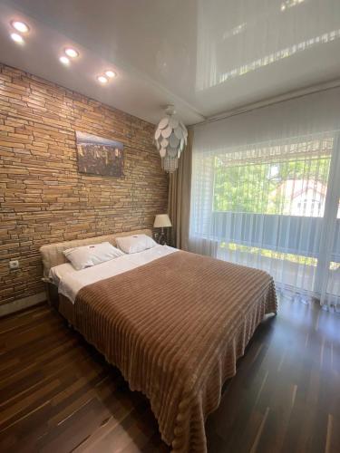 a bedroom with a large bed and a brick wall at Apartments Georg-Grad in Odesa