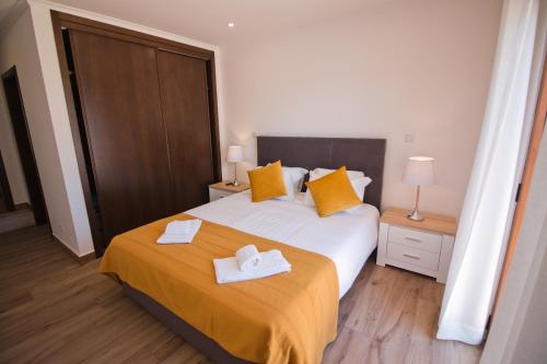 a bedroom with a bed with two towels on it at Casa da Ladeira Branca in Lagos