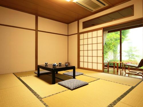 um quarto com uma mesa no meio de um quarto em Ryokan Kamomeso em Sado