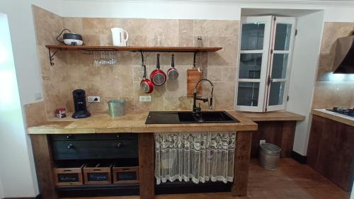 a kitchen with a sink and a counter with pots and pans at Domaine Le Mayne in Chabrignac