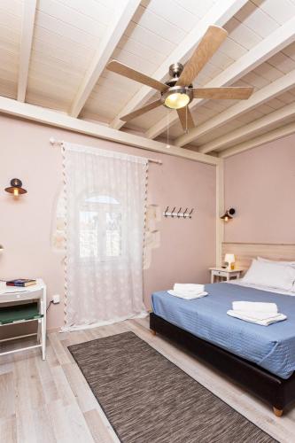 a bedroom with a blue bed and a ceiling fan at Horizon Villa Likotinara in Sellía