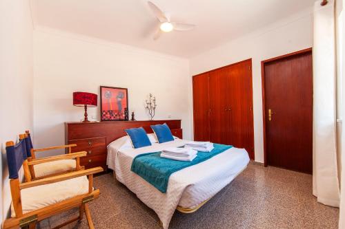 Un dormitorio con una cama con almohadas azules y una silla en Sweet Spot Marina Apartments, en Lagos