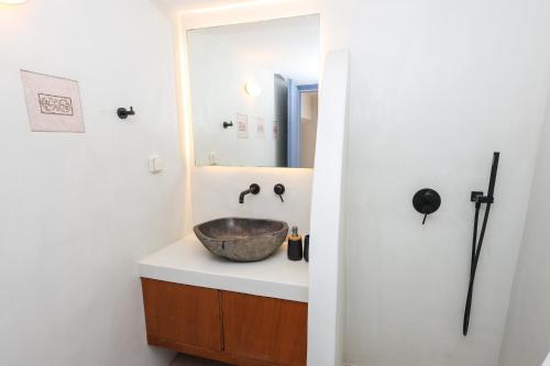 a bathroom with a bowl sink and a mirror at Aeolian Stone Villa in Koilás