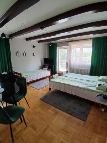 two beds in a room with green curtains at Albatros in Mikołajki