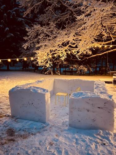 a park covered in snow with a table and chairs at Charming house by the sea in Apšuciems in Apšuciems